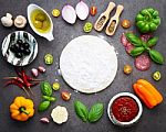 The Ingredients For Homemade Pizza On Dark Stone Background Stock Photo