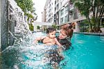 The Kid And Mom Play Together In The Pool Stock Photo