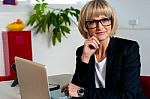 Thoughtful Business Lady Seated In Office Stock Photo