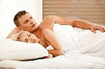 Thoughtful Man In Bed With His Wife Stock Photo