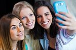 Three Friends Taking Photos With A Smartphone Stock Photo