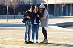 Three Students Girls Using Mobile Phone In The Campus Stock Photo