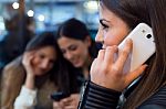 Three Young Woman Using Mobile Phone At Cafe Shop Stock Photo