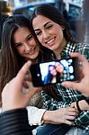 Three Young Woman Using Mobile Phone At Cafe Shop Stock Photo