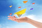 Throwing Paper Plane In Sky Stock Photo