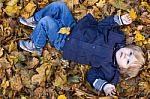 Toddler Blond Boy With Blue Eyes Lays On Bed Of Autumn Fallen Le Stock Photo