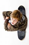 Top View Of Boy Sitting On Skateboard Stock Photo