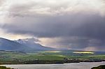 Town On The Lake Behind The Foothills. Spring Rain And Storm In Stock Photo