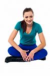 Trendy Girl In Casuals Relaxing On Studio Floor Stock Photo