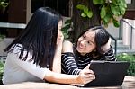 Two Asia Thai High School Student Best Friends Beautiful Girl Using Her Tablet And Funny Stock Photo