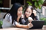 Two Asia Thai High School Student Best Friends Beautiful Girl Using Her Tablet And Funny Stock Photo