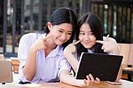 Two Asia Thai High School Student Uniform Best Friends Beautiful Girl Using Her Tablet And Funny Stock Photo