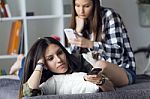 Two Beautiful Young Woman Staying On Sofa At Home Stock Photo