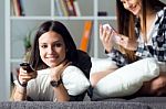 Two Beautiful Young Woman Staying On Sofa At Home Stock Photo