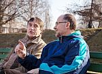 Two Elderly Men Talk On A Park Bench Stock Photo