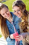 Two Friends Having Fun With Smartphones Stock Photo