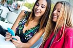 Two Friends Having Fun With Smartphones Stock Photo