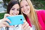 Two Friends Taking Photos With A Smartphone Stock Photo