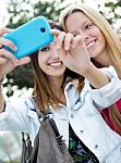 Two Friends Taking Photos With A Smartphone Stock Photo