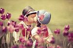 Two Kissing Dolls In Tulip Garden Stock Photo