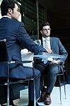 Two Smiling Business Men Have Dinner At Restaurant Stock Photo