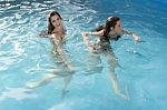 Two Women In The Pool Having Fun Stock Photo