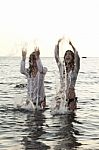 Two Women In The Water Splashing And Having Fun Stock Photo