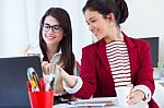 Two Young Businesswomen Working With Laptop In Her Office Stock Photo