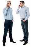 Two Young Men Talking Through Mobile Phone Stock Photo