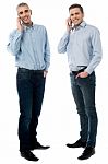 Two Young Men Talking Through Mobile Phone Stock Photo