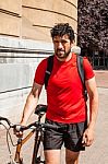 Urban Athlete Walking His Bike Through A City Stock Photo