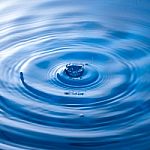 Water Drop Impact With Water Surface, Causing Rings On The Surface Stock Photo