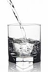 Water With Air Bubbles Pouring Into Glass With Its Reflection, C Stock Photo