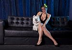 Widow Woman In Black Sexy Dress And White Dog On Sofa Stock Photo