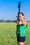 Woman Aiming With Bow And Arrow In Nature Stock Photo