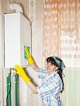 Woman Cleaning A Boiler With A Rag Stock Photo