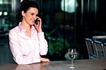 Woman Communicating Over Cellphone To Client Stock Photo