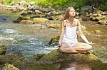 Woman Doing Yoga On Rock Stock Photo