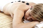 Woman Getting A Spa Treatment With Stone Massage Stock Photo