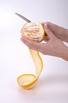 Woman Hands Peeling An Orange With A Knife Stock Photo