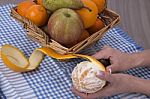 Woman Hands Peeling An Orange With A Knife Stock Photo