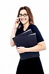 Woman Holding A Folder And Talking On The Phone Stock Photo