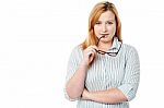 Woman Holding Spectacles And Thinking Stock Photo