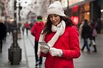 Woman In Red Coat And Wool Cap And Gloves With Smartphone In Han Stock Photo