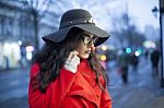 Woman In Red Coat With Smartphone In Hands Going Through The Cit Stock Photo