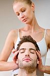 Woman Massaging Mans Temples Stock Photo