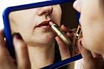 Woman Paints Lips With Lipstick Before A Mirror Stock Photo