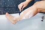 Woman Shaving Her Leg In The Bathroom Stock Photo