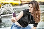 Woman Sitting  And Making Selfie Stock Photo