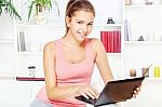 Woman Smiling While Working On Laptop Stock Photo